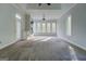 Spacious living room with a fireplace, large windows offering natural light, and neutral carpet at 345 Phillips Dr, Fayetteville, GA 30214