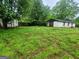 Backyard featuring overgrown grass and two buildings in the background at 30 Millwood Dr, Covington, GA 30016