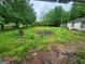 Backyard with overgrown grass and an abandoned trash barrel at 30 Millwood Dr, Covington, GA 30016