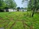 Backyard with a couple of buildings surrounded by overgrown grass at 30 Millwood Dr, Covington, GA 30016