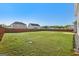 Large backyard with green grass, a wood fence, and neighboring houses in view at 255 Orchid Dr, Mcdonough, GA 30252