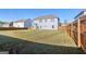 A large grassy yard with a wood fence and view of the back of the house at 255 Orchid Dr, Mcdonough, GA 30252
