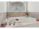 Relaxing bathroom featuring a large soaking tub with chrome fixtures and a window for natural light at 255 Orchid Dr, Mcdonough, GA 30252