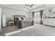 Expansive bedroom with tray ceilings, neutral carpeting, a ceiling fan, and natural light through draped windows at 255 Orchid Dr, Mcdonough, GA 30252