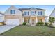 Charming two-story home featuring a well-manicured lawn, brick accents, and a welcoming front porch at 255 Orchid Dr, Mcdonough, GA 30252
