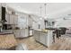 Open kitchen with gray cabinets, an island with stools, stainless steel appliances, and hardwood style floors at 255 Orchid Dr, Mcdonough, GA 30252