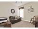 Well-lit bedroom with neutral colors, a comfortable couch, a decorative mirror, and a classic rocking chair at 5910 Stellata Cir, Cumming, GA 30028