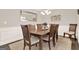 This is a dining room with hardwood floors, a dining table with six chairs, and wainscoting at 5910 Stellata Cir, Cumming, GA 30028