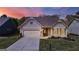 Charming single-Gathering home featuring a two-car garage, manicured lawn, and welcoming front entrance at sunset at 5910 Stellata Cir, Cumming, GA 30028