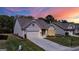 Beautiful single-Gathering home with a well-maintained lawn, two-car garage, and inviting entrance at sunset at 5910 Stellata Cir, Cumming, GA 30028