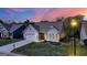 Well-maintained single-Gathering home with a two-car garage, lush front lawn, and inviting entrance during twilight at 5910 Stellata Cir, Cumming, GA 30028