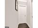 Neutral hallway featuring white doors, white trim and dark wood floors at 5910 Stellata Cir, Cumming, GA 30028