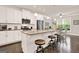Open kitchen boasts white cabinets, stainless steel appliances, granite countertops, and bar stool seating at the island at 5910 Stellata Cir, Cumming, GA 30028