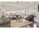Bright, open-concept living room with hardwood floors, a cozy fireplace, and a view of the kitchen at 5910 Stellata Cir, Cumming, GA 30028