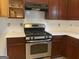 Kitchen featuring stainless steel appliances, dark wood cabinets, and new white countertops at 390 Hulan Way, Lawrenceville, GA 30044