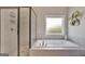 This bright bathroom features a separate glass shower and soaking tub with a frosted window at 185 Discovery Lake Dr, Fayetteville, GA 30215
