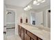Bathroom featuring a granite countertop double vanity, large mirror, and an adjoining bedroom at 185 Discovery Lake Dr, Fayetteville, GA 30215