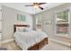 Comfortable bedroom with a wooden bed frame, neutral tones, and two windows for natural light at 185 Discovery Lake Dr, Fayetteville, GA 30215