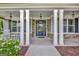Welcoming front porch with stone accents, rocking chairs, and a decorative glass front door at 185 Discovery Lake Dr, Fayetteville, GA 30215