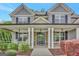 Charming front porch with stone accents, white columns, and decorative landscaping at 185 Discovery Lake Dr, Fayetteville, GA 30215