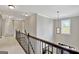 Upstairs hallway with modern lighting, iron railing, and view of the home's entry at 185 Discovery Lake Dr, Fayetteville, GA 30215