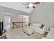 Open loft area with vaulted ceilings, neutral walls, railing, and a plush couch at 185 Discovery Lake Dr, Fayetteville, GA 30215
