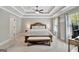 Spacious main bedroom featuring a tray ceiling, ceiling fan, and a decorative bench at 185 Discovery Lake Dr, Fayetteville, GA 30215
