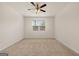 A neutral bedroom with carpet and ceiling fan with a large window overlooking the front yard at 1626 Palladian Way # 118, Lithonia, GA 30058