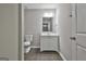 A neutral bathroom featuring a single sink vanity, toilet, and wood look flooring at 28 Willow Ridge Dr, Hampton, GA 30228