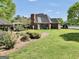 Manicured backyard with brick home, gazebo, outdoor seating, and lush garden spaces, perfect for entertaining at 39 Gabrielle Ct, Stockbridge, GA 30281