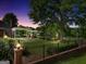 Fenced backyard and outdoor living space with a gazebo, manicured lawn, and mature trees at dusk at 39 Gabrielle Ct, Stockbridge, GA 30281