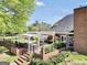 View of the backyard showing a white pergola, brick outdoor grill and fenced yard with landscaping at 39 Gabrielle Ct, Stockbridge, GA 30281
