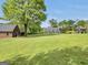 A serene backyard featuring a brick home, gazebo, lush lawn, and mature trees for ultimate relaxation at 39 Gabrielle Ct, Stockbridge, GA 30281