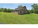 A large barn with a metal roof sits in a grassy field under a clear blue sky at 39 Gabrielle Ct, Stockbridge, GA 30281