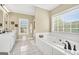 Bright bathroom with a soaking tub, vanity, white cabinets, and large window at 39 Gabrielle Ct, Stockbridge, GA 30281