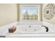 White tub with tile surround, matte black fixtures and a bright window view at 39 Gabrielle Ct, Stockbridge, GA 30281