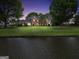 Stunning brick home with a well-manicured lawn and water view at dusk at 39 Gabrielle Ct, Stockbridge, GA 30281