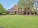 Elegant brick home with a lush green lawn and mature trees, exuding curb appeal and timeless charm at 39 Gabrielle Ct, Stockbridge, GA 30281