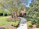 Brick home with a winding walkway, surrounded by mature trees, landscaping, and a classic street lamp at 39 Gabrielle Ct, Stockbridge, GA 30281