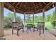 Gazebo interior featuring chairs and a small table perfect for relaxation and enjoying the green backyard at 39 Gabrielle Ct, Stockbridge, GA 30281