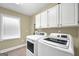 Well-lit laundry room with modern washer and dryer units and ample cabinet space at 39 Gabrielle Ct, Stockbridge, GA 30281