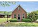 Exterior of an outbuilding with brick facade, multiple windows, and a brick pathway at 39 Gabrielle Ct, Stockbridge, GA 30281