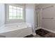 Modern bathroom with a soaking tub, glass shower, and neutral tones at 3065 Willow Park Dr, Dacula, GA 30019