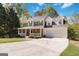 Traditional home with covered porch, stone accents, two-car garage, long driveway, and ample front yard at 3065 Willow Park Dr, Dacula, GA 30019