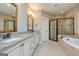 This primary bathroom features a bathtub, glass shower, dual vanity, and granite countertops at 410 Wicklow St, Tyrone, GA 30290