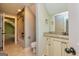 Well-lit bathroom with neutral tilework, bathtub with shower, and a granite-topped vanity sink at 410 Wicklow St, Tyrone, GA 30290