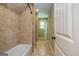 Well-lit bathroom features neutral tilework, bathtub with shower, and an open doorway at 410 Wicklow St, Tyrone, GA 30290