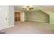 Large bedroom with neutral walls and plush carpet, with doorway access to another room and staircase at 410 Wicklow St, Tyrone, GA 30290