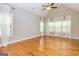 The airy primary bedroom is bright with lots of windows and hardwood floors, featuring a vaulted ceiling and ceiling fan at 410 Wicklow St, Tyrone, GA 30290