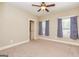 Neutral bedroom with plush carpeting, ceiling fan, and two windows dressed with blue curtains at 410 Wicklow St, Tyrone, GA 30290